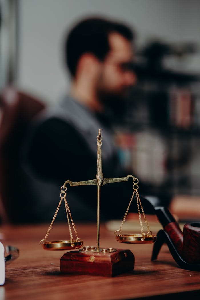 Close-up of justice scales and pipe on a lawyers desk, emphasizing legal themes.